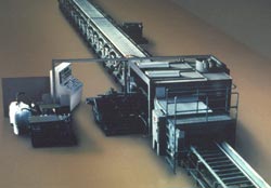 This Building Panel machine produces insulated metal building panels. Movement is toward the top of the picture.