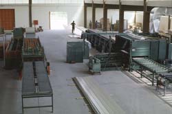 This picture shows a metal panel fabricator on the left and the Foamboarder rigid panel line on the right.