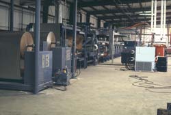 The unwind stands are shown here, upstream of the chemical lay-down table.Then the Foamboarder in the background.